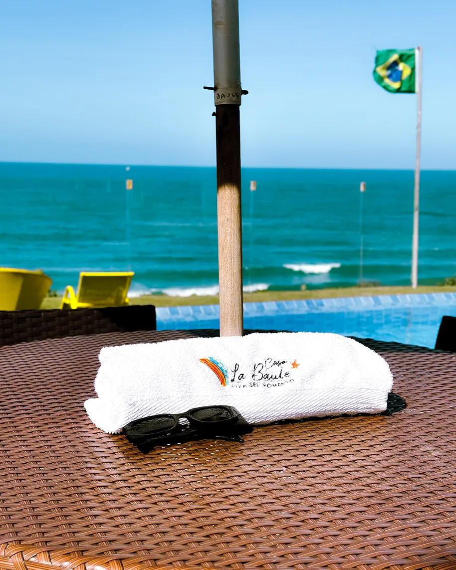 Toalha personalizada Casa La Baule dobrada sobre espreguiçadeira